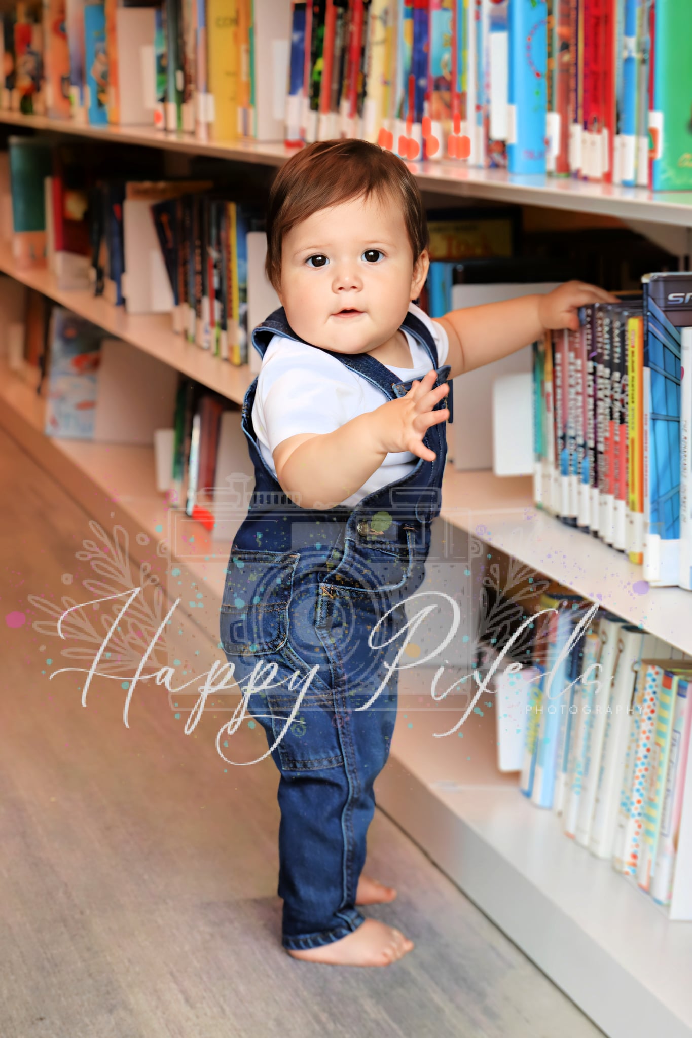 Toddler standing beside a wall of books
