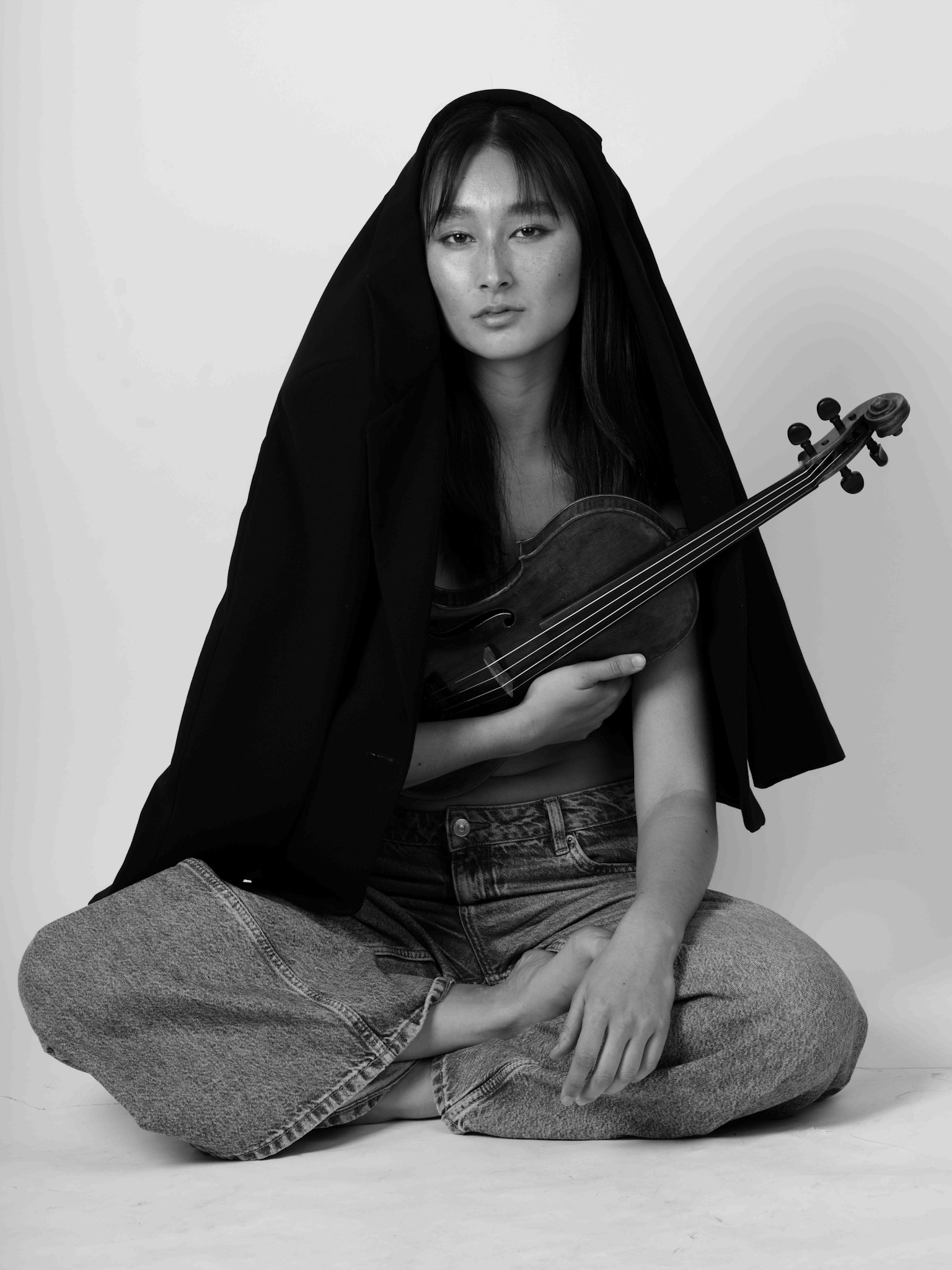 Maya Kilburn seated with her violin, black-and-white portrait