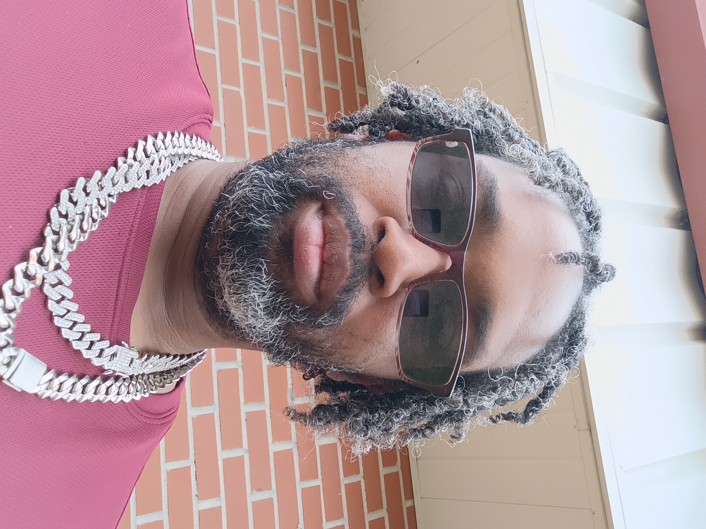 Portrait of Marquis Ross, Founder and President of Pure Hustle Records LLC, wearing sunglasses and a chain