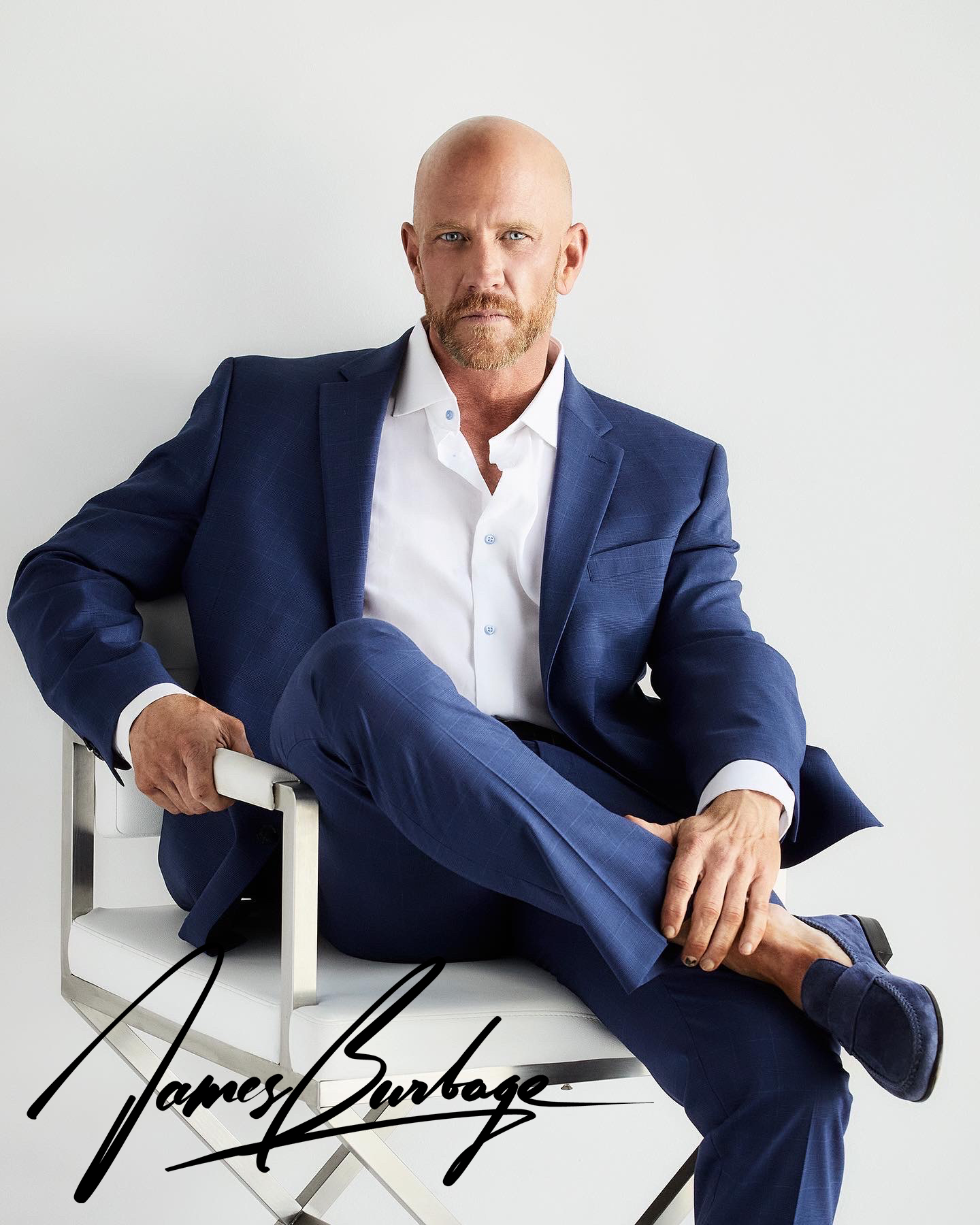 James Burbage seated in a tailored blue suit