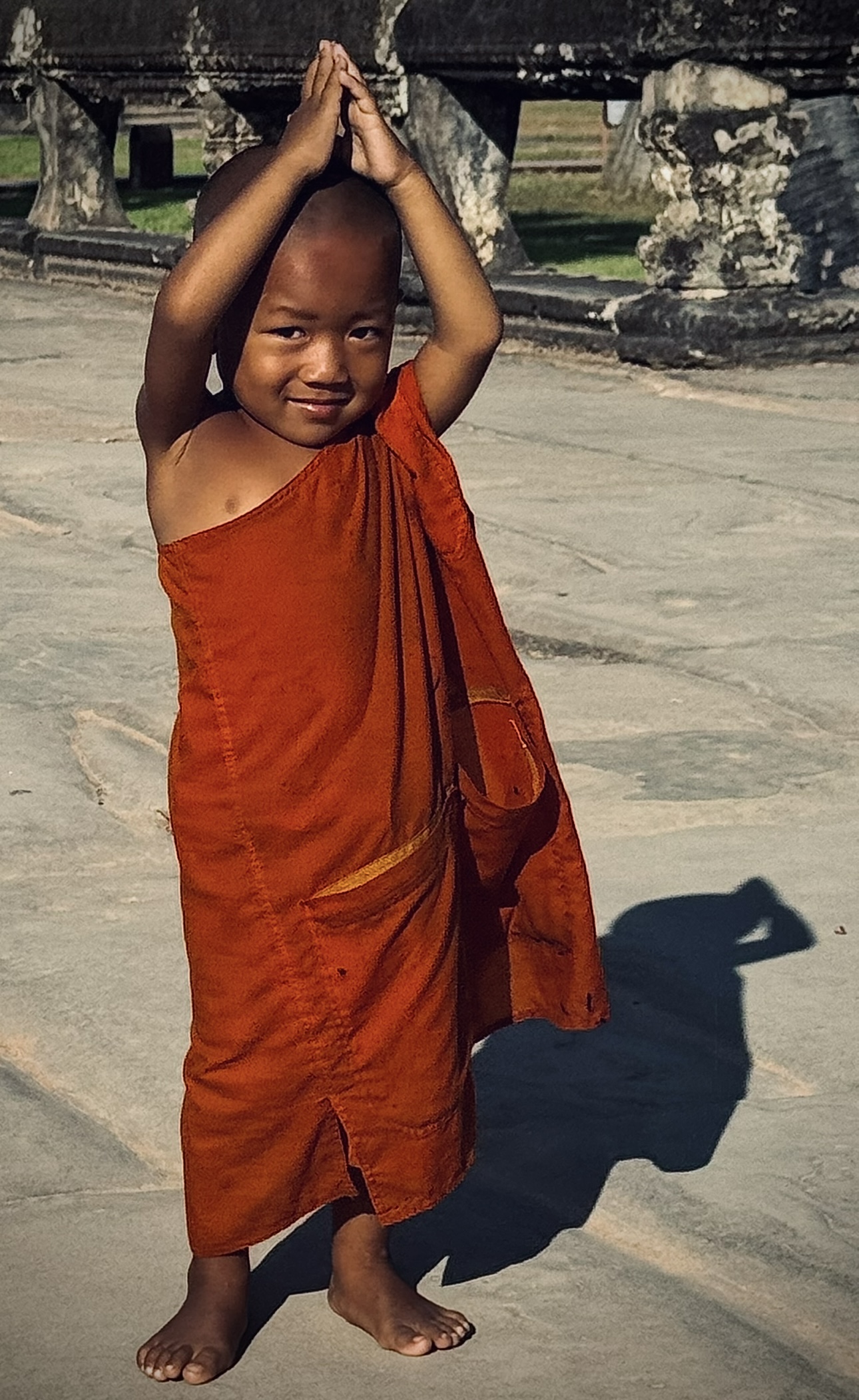 Young novice monk playing in the temple courtyard
