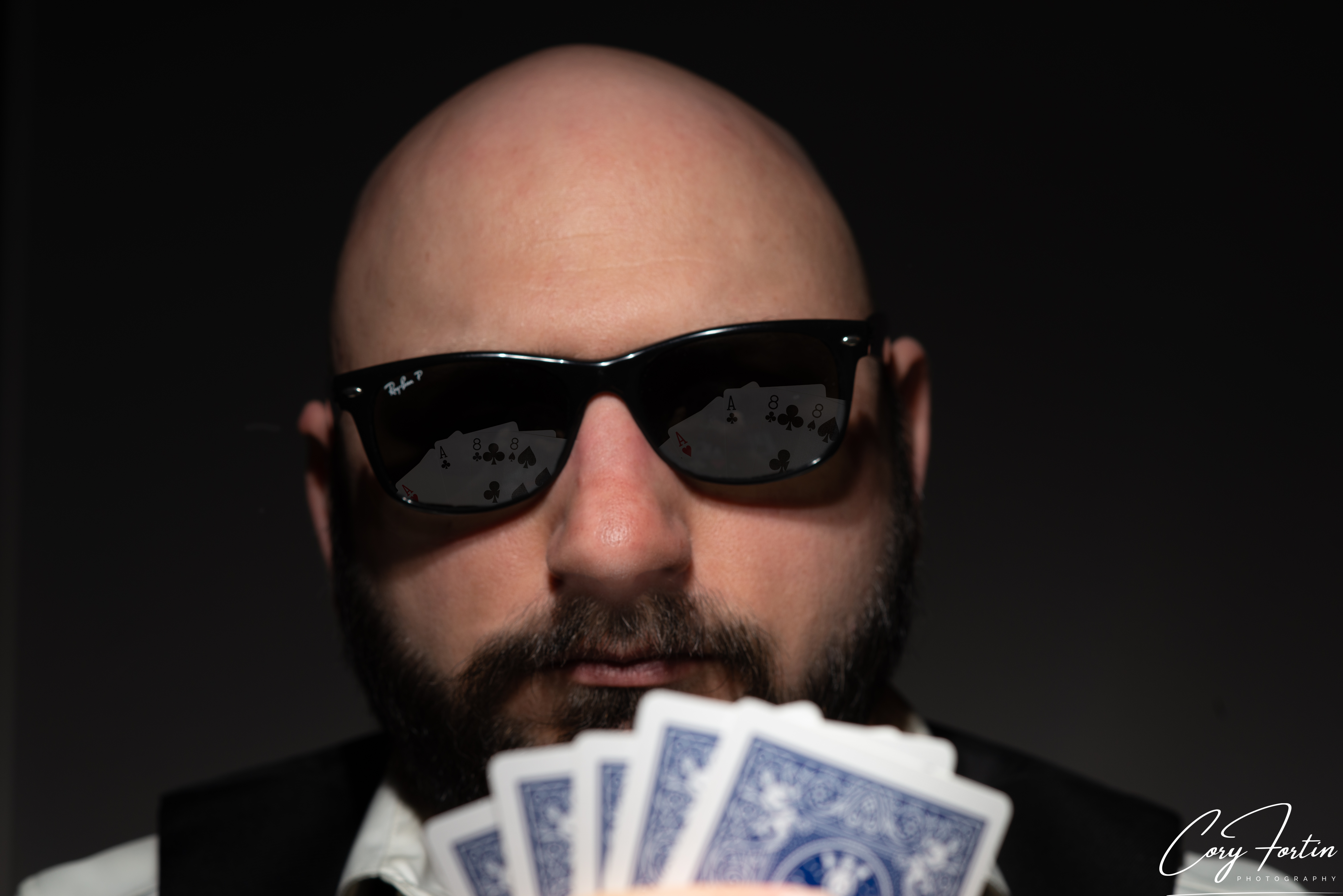 Character portrait of a man holding a fan of playing cards