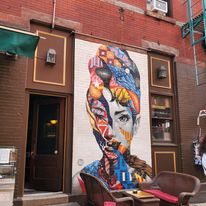 Colorful portrait mural on the side of a building